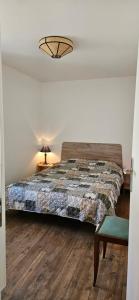 een slaapkamer met een bed, een tafel en een stoel bij Maison au bord du Blavet in Le Pener