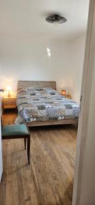 een slaapkamer met een bed en een stoel erin bij Maison au bord du Blavet in Le Pener