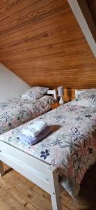 een slaapkamer met een bed met een bloemenbed bij Maison au bord du Blavet in Le Pener