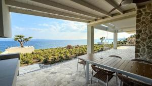 een terras met een tafel en stoelen en de oceaan bij Eosea Helios in Ierissos