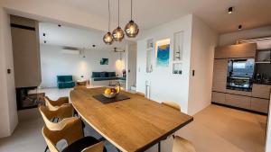 een keuken en eetkamer met een houten tafel en stoelen bij Eosea Helios in Ierissos +27 foto's