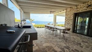 een keuken met een tafel en stoelen en de oceaan bij Eosea Helios in Ierissos +27 foto's