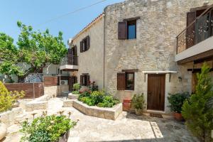 una casa in pietra con cortile con piante di Luxurious Villa with Private Pool ad Arménoi