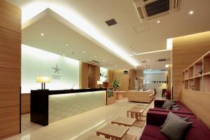 a hospital lobby with a purple couch and tables at Candeo Hotels Shizuoka Shimada in Shimada