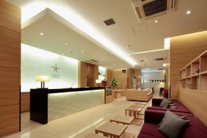 島田市にあるカンデオホテルズ静岡島田の紫色のソファとテーブルが備わる病院ロビー