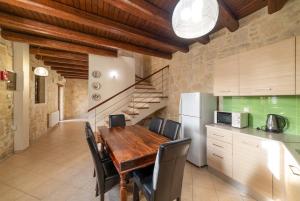 una cucina e una sala da pranzo con tavolo e sedie in legno di Luxurious Villa with Private Pool ad Arménoi