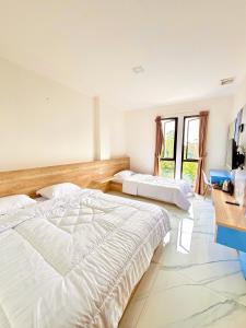 a bedroom with two beds and a television in it at Hotel Asia Express near Farmhouse Lembang in Lembang