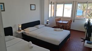 a bedroom with two beds and a table with a chair at Blife Mariangya private rooms at Faro beach in Faro +20 photos