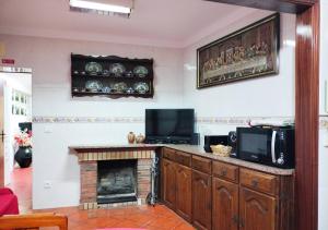 un salon avec une cheminée et une télévision dans l'établissement Casa da Aldeia - Monte Redondo, à Figueira de Lorvão