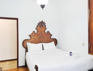 une chambre avec un lit blanc avec une tête de lit en bois dans l'établissement Casa da Aldeia - Monte Redondo, à Figueira de Lorvão 41 autres photos