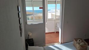 een slaapkamer met een bed en uitzicht op een balkon bij Blife Mariangya private rooms at Faro beach in Faro +21 foto's