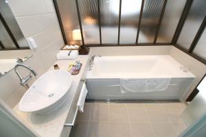 a bathroom with a tub and a sink at Bricks Hotel in Seoul