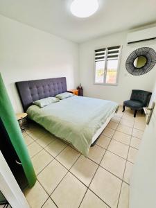 een slaapkamer met een bed en een stoel bij L Escapade Rurale in Usseau