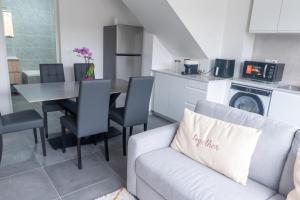 ein Wohnzimmer mit einem Sofa und einem Tisch in der Küche in der Unterkunft Le Van G-Home in Auvers-sur-Oise + 14 Fotos