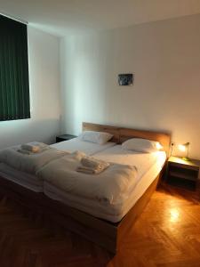 een slaapkamer met een groot bed met witte lakens bij MIA Apartment in Yambol