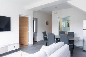 een woonkamer met een witte bank en een tafel bij Le Van G-Home in Auvers-sur-Oise