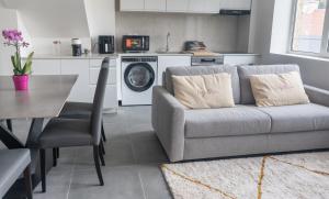 ein Wohnzimmer mit Sofa und eine Küche in der Unterkunft Le Van G-Home in Auvers-sur-Oise