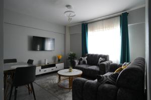 een woonkamer met twee banken en een tafel bij Modern 2-Bedroom Apartment Near Kisumu CBD, Free WiFi, Parking & Security in Kisumu