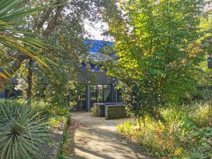 een loopbrug naar een gebouw met bomen en planten bij Le Cours des Arts in Nantes