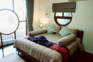 een slaapkamer met een bed met blauwe kussens en een raam bij Grandpa's House in Ko Klang