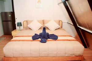 een slaapkamer met een bed met een blauwe boog erop bij Grandpa's House in Ko Klang +13 foto's