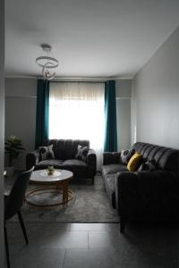 een woonkamer met een bank en een tafel bij Modern 2-Bedroom Apartment Near Kisumu CBD, Free WiFi, Parking & Security in Kisumu +36 foto's