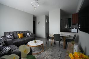 een woonkamer met een bank en een tafel bij Modern 2-Bedroom Apartment Near Kisumu CBD, Free WiFi, Parking & Security in Kisumu