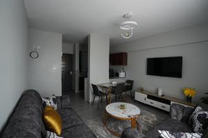 een woonkamer met een bank en een tafel bij Modern 2-Bedroom Apartment Near Kisumu CBD, Free WiFi, Parking & Security in Kisumu