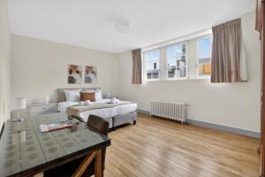 a bedroom with a bed and a table and windows at Maison Lombard by Reside in Brussels