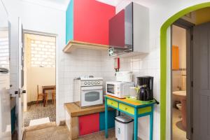 a small kitchen with colorful cabinets and a stove at Blife Sonya private rooms at Faro beach in Faro