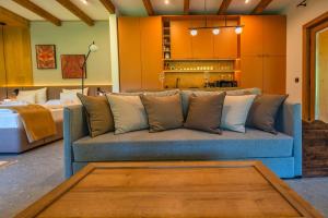 a living room with a blue couch and a kitchen at MyNest - Mountain luxury cabin in Plăeşii de Sus