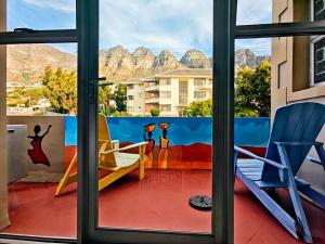un balcone con vista sulle montagne attraverso una finestra. di African Groove Camps Bay a Città del Capo