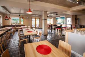 a dining room with wooden tables and chairs at Chata pod Lysou in Malenovice