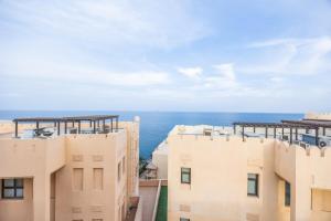 een afbeelding van twee gebouwen met de oceaan op de achtergrond bij Bloomfields al-Fujairah 4BR Villa, Beach Access in Rūl Ḑadnā