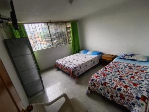 a bedroom with two beds and a window at Hotel mi casita in Bogotá