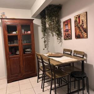 a dining room table with chairs and a wooden cabinet at Garden house in Arta