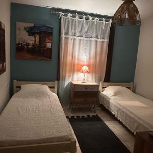 a bedroom with two beds and a table with a lamp at Garden house in Arta