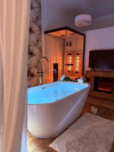 La salle de bains est pourvue d'une grande baignoire blanche et d'une télévision. dans l'établissement Ama Esclusive Spa Florence, à Florence