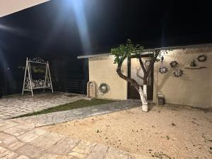 a building with a tree in a courtyard at night at Garden house in Arta