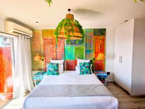 una camera da letto con un letto grande e un lampadario di African Groove Camps Bay a Città del Capo