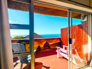 een balkon met uitzicht op de oceaan bij African Groove Camps Bay in Kaapstad