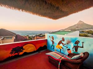 un balcone con un murale sul muro e due sedie di African Groove Camps Bay a Città del Capo Altre 63 foto
