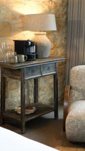 a table with a lamp on top of it at Schoolhouse Snug in Moreton in Marsh +2 photos