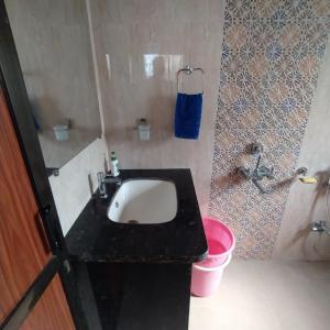ein Badezimmer mit Waschbecken und schwarzer Ablage in der Unterkunft Om sai villa in Neral