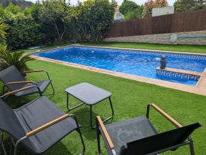 eine Gruppe von Stühlen und einem Tisch neben einem Swimmingpool in der Unterkunft Winahost el Rincón de Creixell in Creixell