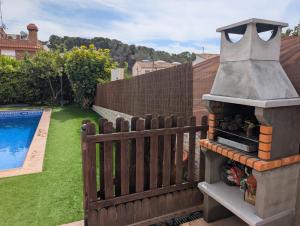 Ein Hinterhof mit einem Pizzaofen im Freien neben einem Zaun in der Unterkunft Winahost el Rincón de Creixell in Creixell