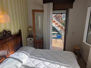 ein Schlafzimmer mit einem Bett und einer Tür zu einem Balkon in der Unterkunft Winahost el Rincón de Creixell in Creixell + 19 Fotos