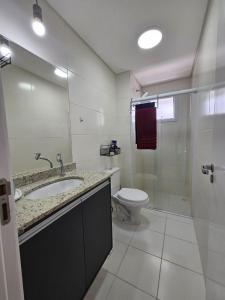 een badkamer met een toilet, een wastafel en een douche bij bwelcome - Apt with lovely view in Bertioga