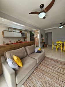 een woonkamer met een bank met gele kussens bij bwelcome - Apt with lovely view in Bertioga