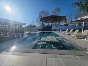 a swimming pool with an umbrella and chairs at ZEN Villa in Rrushkull